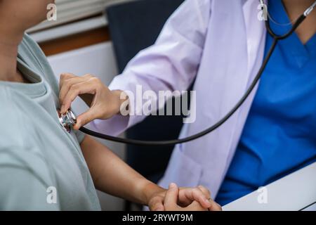 Arzt im Gesundheitswesen. Berufsarzt im weißen Uniform-Mantel Interview mit dem Patienten, der seine männliche Patie beruhigt Stockfoto