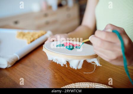 Stanznadel. Asiatische Frau, die handgemachtes Hobby-Stricken in der Atelierwerkstatt herstellt. Designer-Arbeitsplatz Handgefertigtes Bastelprojekt DIY Embro Stockfoto