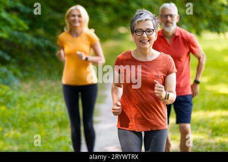 Gruppe aktiver Senioren, die im Park zusammen laufen Stockfoto
