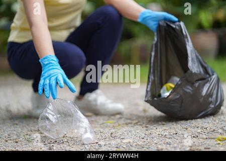 Freiwillige Wohltätigkeitsorganisation womanÂ Hand hält Müllbeutel und Plastikflaschenmüll zum Recycling für die Reinigung im Park Freiwilligendienst Stockfoto