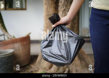 Freiwillige Wohltätigkeitsorganisation womanÂ Hand hält Müllbeutel und Plastikflaschenmüll zum Recycling für die Reinigung im Park Freiwilligendienst Stockfoto