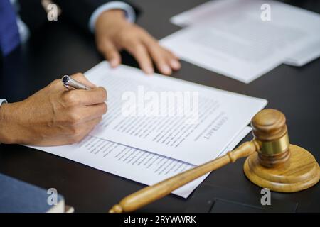 Rechtsberater präsentiert auf dem Client einen unterzeichneten Vertrag mit Hammer und rechtlichen Gesetz. Justiz und Rechtsanwalt Konzept Stockfoto