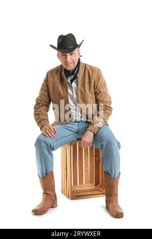 Reifer Cowboy, der auf weißem Hintergrund sitzt Stockfoto