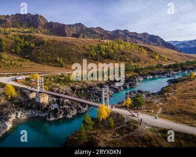 Die malerische Oroctoi (Oroctoy) Brücke über den blau türkisfarbenen Katun Fluss in den Wiesen und Wäldern der Altai Berge in Sibirien (Luftbild). Stockfoto