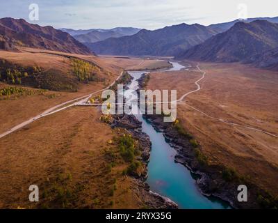 Die malerische Oroctoi (Oroctoy) Brücke über den blau türkisfarbenen Katun Fluss in den Wiesen und Wäldern der Altai Berge in Sibirien (Luftbild). Stockfoto
