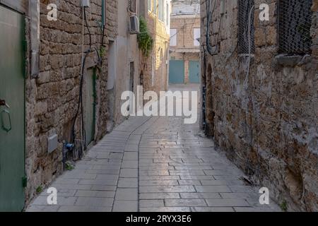 Straße in der Altstadt von Akko in Israel. Kopfsteinpflasterstraße zwischen traditionellen steinigen Häusern im alten Akkon. Stockfoto