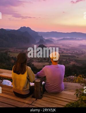 Paare beobachten den Sonnenaufgang mit Nebel in Phu Langka im Norden Thailands, Phu Langka National Park Stockfoto