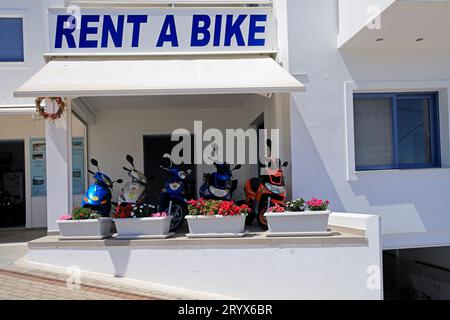 Fahrradverleih und Motorradverleih mit Blumentöpfen, Megalochori, Insel Agistri, Saronische Inselgruppe, Griechenland. Vom Mai 2023 Stockfoto