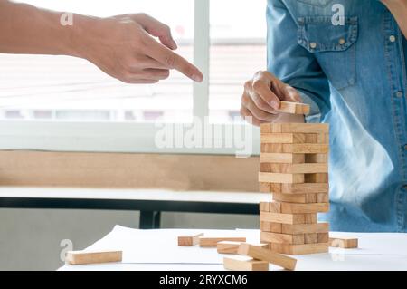 Gruppe von Freunden, die Holzblöcke spielen gameÂ auf dem Tisch gefaltetes Puzzle Holding Blöcke Holzspiel Planung Risiko und Strategie im Bus Stockfoto