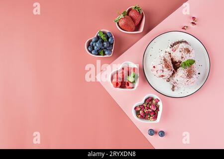 Teller mit Eiskugeln mit Beeren und kleinen Tellern in Form von Herzen mit frischen Beeren, Erdbeeren, Himbeeren, Stockfoto