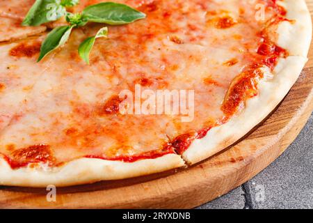 Pizza margarita auf Holzbrett auf dunklem Hintergrund. Nahaufnahme Stockfoto