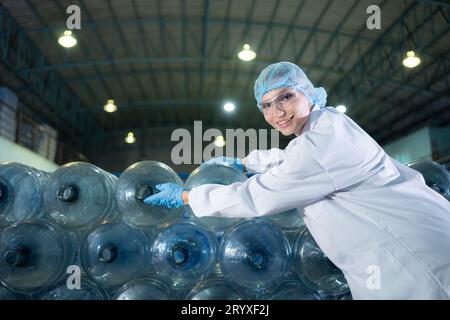 Porträt eines Wissenschaftlers in der Trinkwasserfabrik mit einer Leiter, Blick auf die Wassertanks oben und Untersuchung Stockfoto