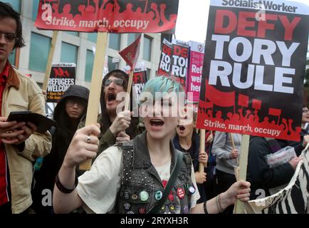 Manchester, Großbritannien. Oktober 2023. Demonstranten singen Parolen, während sie während der Demonstration regierungsfeindliche Zeichen halten. Die Demonstranten fordern menschenwürdige Gesundheit, Wohnungen, Arbeitsplätze und Bildung. Die von der Volksversammlung organisierte Kundgebung wurde abgehalten, um gegen die Politik der Regierung zu protestieren, während die Konservative Party Conference im Stadtzentrum von Manchester stattfand. Quelle: SOPA Images Limited/Alamy Live News Stockfoto