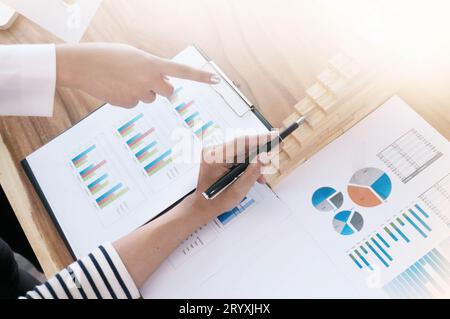 Team, das an einem Projekt im Loft Office arbeitet. Zwei Frauen diskutieren über Marketingplan. Laptop und Papierkram auf dem Tisch. Stockfoto