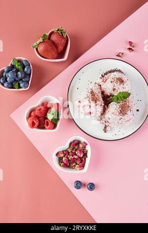 Teller mit Eiskugeln mit Beeren und kleinen Tellern in Form von Herzen mit frischen Beeren, Erdbeeren, Himbeeren, Stockfoto