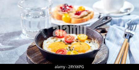 Spiegeleier in gusseisernen Spiegeleiern. Konzept für ein sonniges Frühstück am Morgen Stockfoto