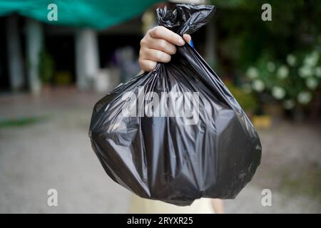 Freiwillige Wohltätigkeitsorganisation womanÂ Hand hält Müllbeutel und Plastikflaschenmüll zum Recycling für die Reinigung im Park Freiwilligendienst Stockfoto