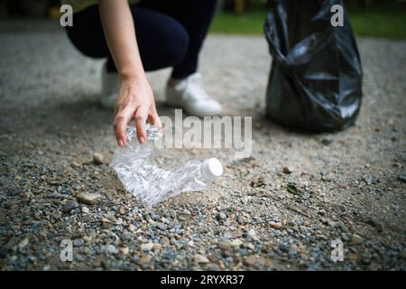 Freiwillige Wohltätigkeitsorganisation womanÂ Hand hält Müllbeutel und Plastikflaschenmüll zum Recycling für die Reinigung im Park Freiwilligendienst Stockfoto