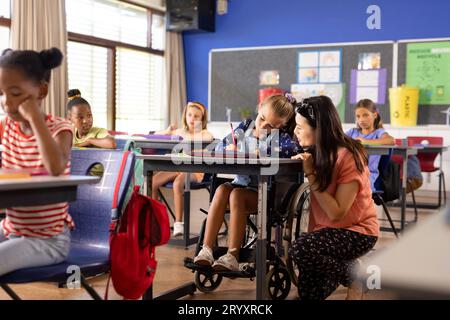 Vielfältige Lehrerin und Schülerin im Rollstuhl in der Grundschule Stockfoto