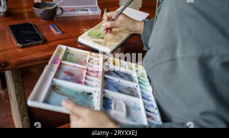 Student im Kunststudio. Hand halten Künstler Pinsel mischen Farbe Ölgemälde auf Palette Kunst Kreativität und Menschen conceptÂ Stockfoto