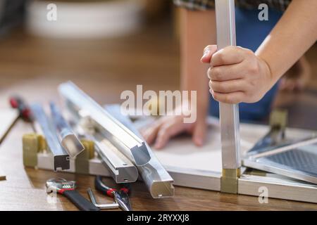 Asiatische Frau repariert Möbel-Renovierung selbst, indem sie Ausrüstung zum selbermachen von Möbeln verwendet, die zu Hause auf dem Boden sitzen Stockfoto