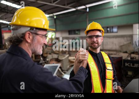 Ingenieure und Techniker prüfen die elektrische Anlage und reparieren die mechanische Anlage im Schaltschrank der Maschine. In Stockfoto
