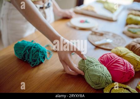 Stanznadel. Asiatische Frau, die handgemachtes Hobby-Stricken in der Atelierwerkstatt herstellt. Designer-Arbeitsplatz Handgefertigtes Bastelprojekt DIY Embro Stockfoto