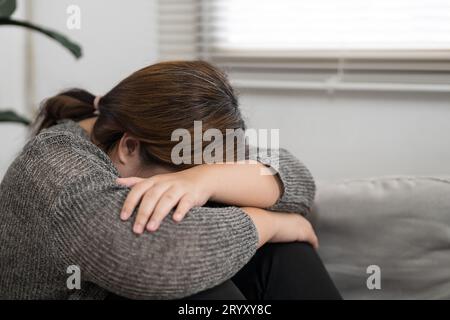 Traurige übergewichtige Frau, die über Probleme auf dem Sofa nachdenkt, verärgerte Mädchen, das sich einsam fühlt und traurig von schlechter Beziehung oder Depres ist Stockfoto