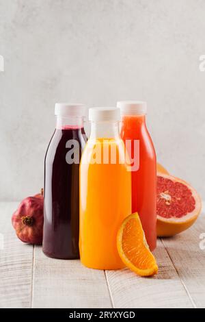 Frisch gepresste Orangen-, Grapefruit- und Granatapfelsäfte in transparenten Flaschen. Gesunde Ernährung Stockfoto