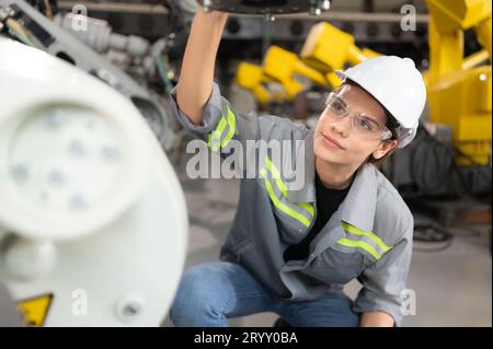 Eine Ingenieurin installiert ein Programm auf einem Roboterarm in einem Roboterlager. Und prüfen Sie die Funktion, bevor Sie die Maschine t senden Stockfoto