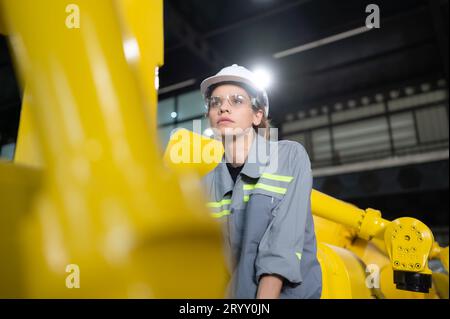 Eine Ingenieurin installiert ein Programm auf einem Roboterarm in einem Roboterlager. Und prüfen Sie die Funktion, bevor Sie die Maschine t senden Stockfoto