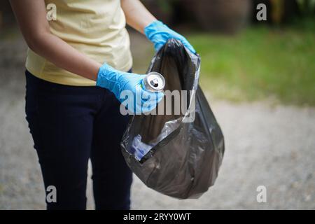 Freiwillige Wohltätigkeitsorganisation womanÂ Hand hält Müllbeutel und Plastikflaschenmüll zum Recycling für die Reinigung im Park Freiwilligendienst Stockfoto