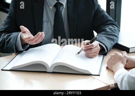 Rechtsberater präsentiert auf dem Client einen unterzeichneten Vertrag mit Hammer und rechtlichen Gesetz. Justiz und Rechtsanwalt Konzept. Stockfoto
