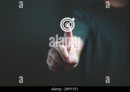 Der Geschäftsmann berührt mit der Hand die Zielscheibe, um Ziele und Ziele für Unternehmensinvestitionen festzulegen. Geschäftsfinanzierungen Stockfoto