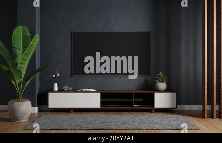 Moderner TV-fernseher, der auf dem dunkelblauen Hintergrund hängt, mit Holzschrank im Wohnzimmer. Innenarchitektur A Stockfoto