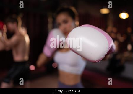 Porträt einer Frau, die Muay Thai lernt, die Stärke des Körpers aufzubauen und ihn zur Selbstverteidigung zu nutzen. Stockfoto