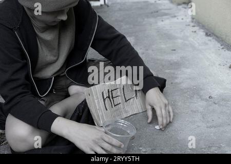 Bettler. Obdachloser Junge oder Teenager bettelt um Almosen. Schwarz und weiß. Stockfoto
