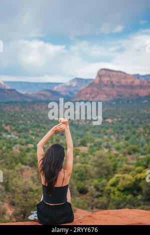 Frau genießt den Blick auf die Landschaft von Sedona von der Spitze des Bell Rock Wanderweges, der für seine vielen Energie-Wirbel und berühmt ist Stockfoto