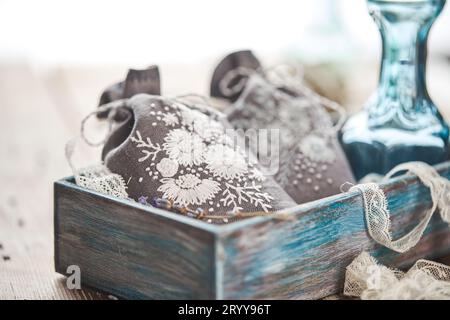 Beutel mit Stickerei gefüllt mit Lavendel auf hölzernem Hintergrund Stockfoto