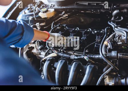 Automechaniker hält das Getriebeöl auf Kundenwunsch in der Werkstatt der Autowerkstatt an das Wartungsfahrzeug. Motorreparatur Stockfoto