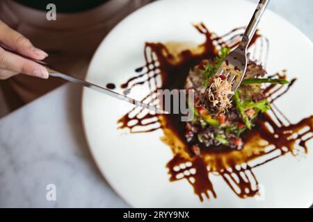 Luxuriöse Tischeinstellungen für gehobene Küche serviert und dekorierte Tisch mit Speisen für Gäste im Restaurant Stockfoto