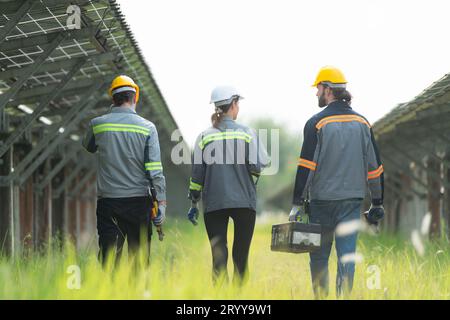 Ingenieure und Techniker entladen reparierte Solarpaneele, die auf den Reihen von Solarzellen installiert werden, die auf Hunderten von A angeordnet sind Stockfoto