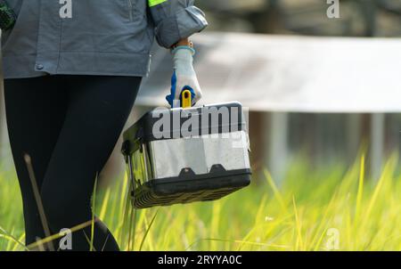 Ingenieure und Techniker entladen reparierte Solarpaneele, die auf den Reihen von Solarzellen installiert werden, die auf Hunderten von A angeordnet sind Stockfoto