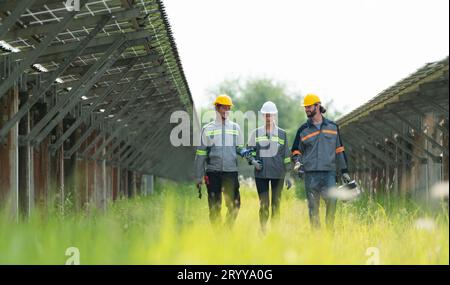 Ingenieure und Techniker entladen reparierte Solarpaneele, die auf den Reihen von Solarzellen installiert werden, die auf Hunderten von A angeordnet sind Stockfoto