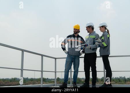 Auf dem Dach eines großen Solarspeichers baut Ein Team von Elektrotechnikern, die Solarpaneele inspizieren Stockfoto