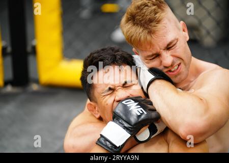 Mixed Martial Art: Wenn der Gegner niedergeschlagen wird, erwürgen Sie mit Ihren Händen den Hals Ihres Gegners. Erschweren es f Stockfoto