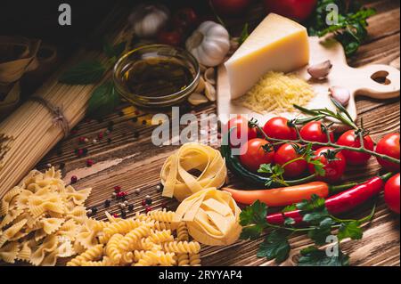 Leckere, appetitliche italienische Spaghetti-Pasta-Zutaten für die Küche mit Tomaten, Käse-Parmesan, Olivenöl, Fettuccine und Stockfoto