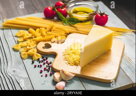 Leckere, appetitliche italienische Spaghetti-Pasta-Zutaten für die Küche mit Tomaten, Käse-Parmesan, Olivenöl, Fettuccine und Stockfoto