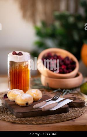 Mit Schokolade gefüllter Keks mit Besteck auf einem Schneidebrett, serviert mit aufschäumendem Apfelsaft, roten Brombeeren, Mandarinen und einer Jack o'Laterne im bac Stockfoto