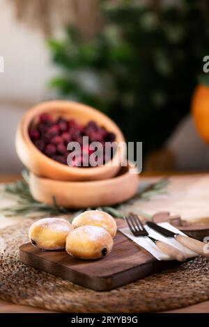 Mit Schokolade gefüllter Keks mit Besteck auf einem Schneidebrett, serviert mit aufschäumendem Apfelsaft, roten Brombeeren, Mandarinen und einer Jack o'Laterne im bac Stockfoto